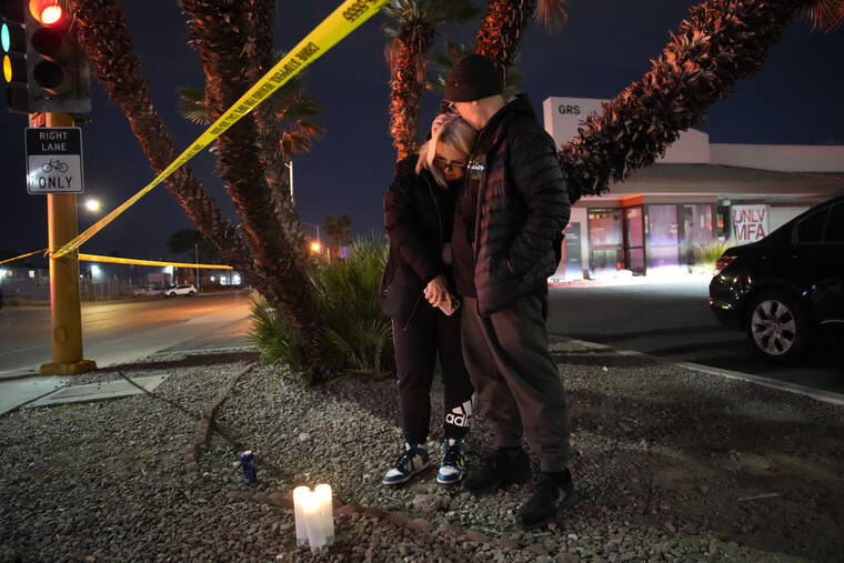 ASSOCIATED PRESS
                                Sean Hathcock, right, kisses Michelle Ashley after the two left candles for victims of a shooting at the University of Nevada, Las Vegas, Wednesday, Dec. 6, in Las Vegas. The two graduated from the school and live nearby.