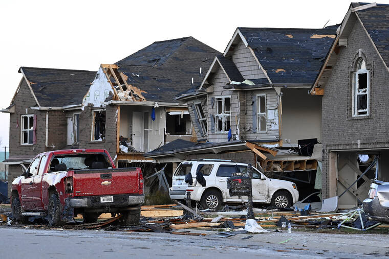 Damaged vehicles and homes sit in the aftermath of storms in the West Creek Farms neighborhood on Sunday, Dec. 10, 2023, Clarksville, Tenn. Central Tennessee residents and emergency workers are continuing the cleanup from severe weekend storms. (AP Photo/Mark Zaleski)