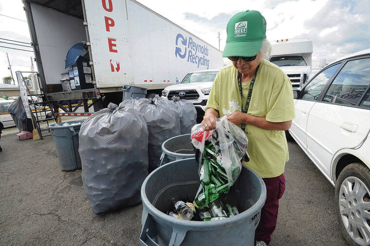 STAR-ADVERTISER / 2019
                                Amy Wannomae deposits collected and donated recyclable containers to the Reynolds Recycling trailer in Moiliili.