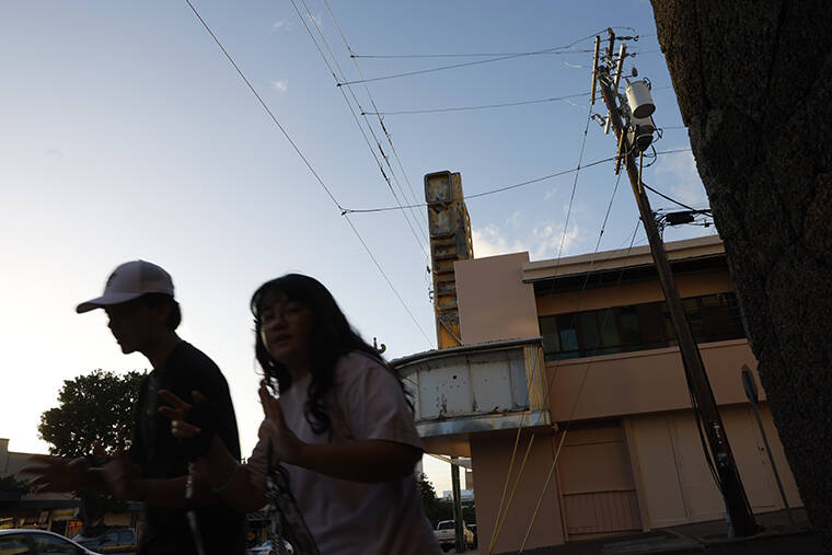 JAMM AQUINO / JAQUINO@STARADVERTISER.COM
                                People walk past the Queen Theatre building on Thursday in Kaimuki.