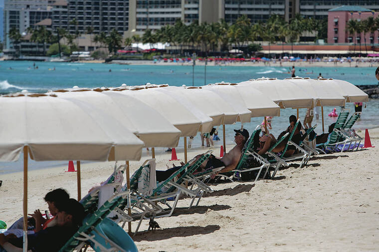 CINDY ELLEN RUSSELL / APRIL 30
                                Hawaii tourism is making a slow comeback. Visitors relax at Kuhio Beach in Waikiki.