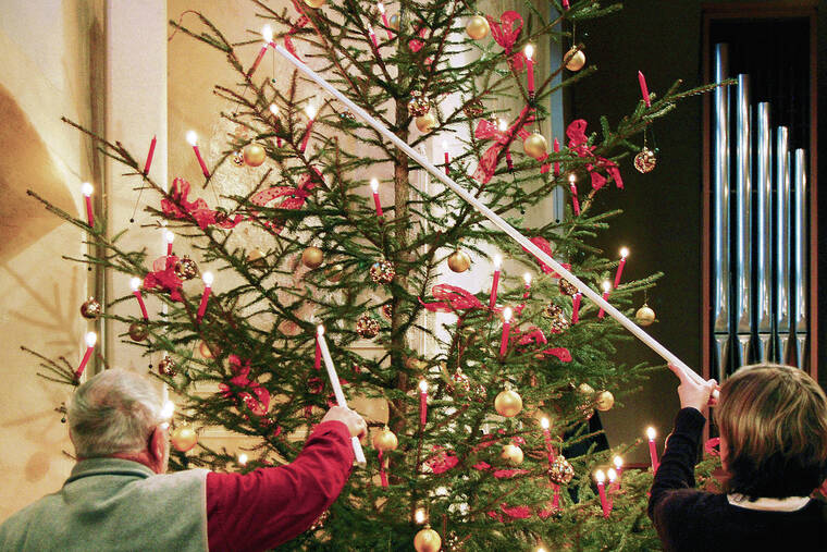 COURTESY CAMERON HEWITT
                                In Switzerland, some families still use real candles to adorn their Christmas tree.